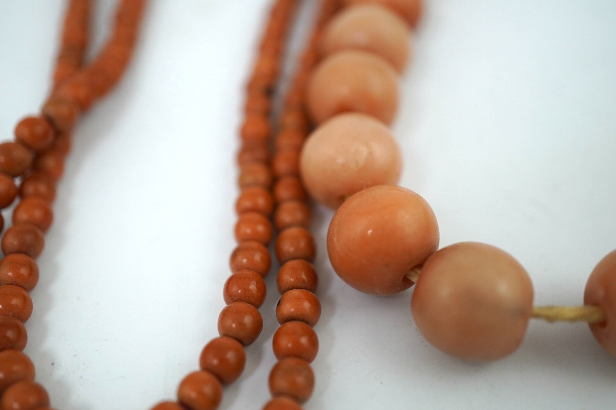 A Chinese coral bead rosary, 58cm drop and a pink soapstone bead necklace, 19.5cm. Condition - fair